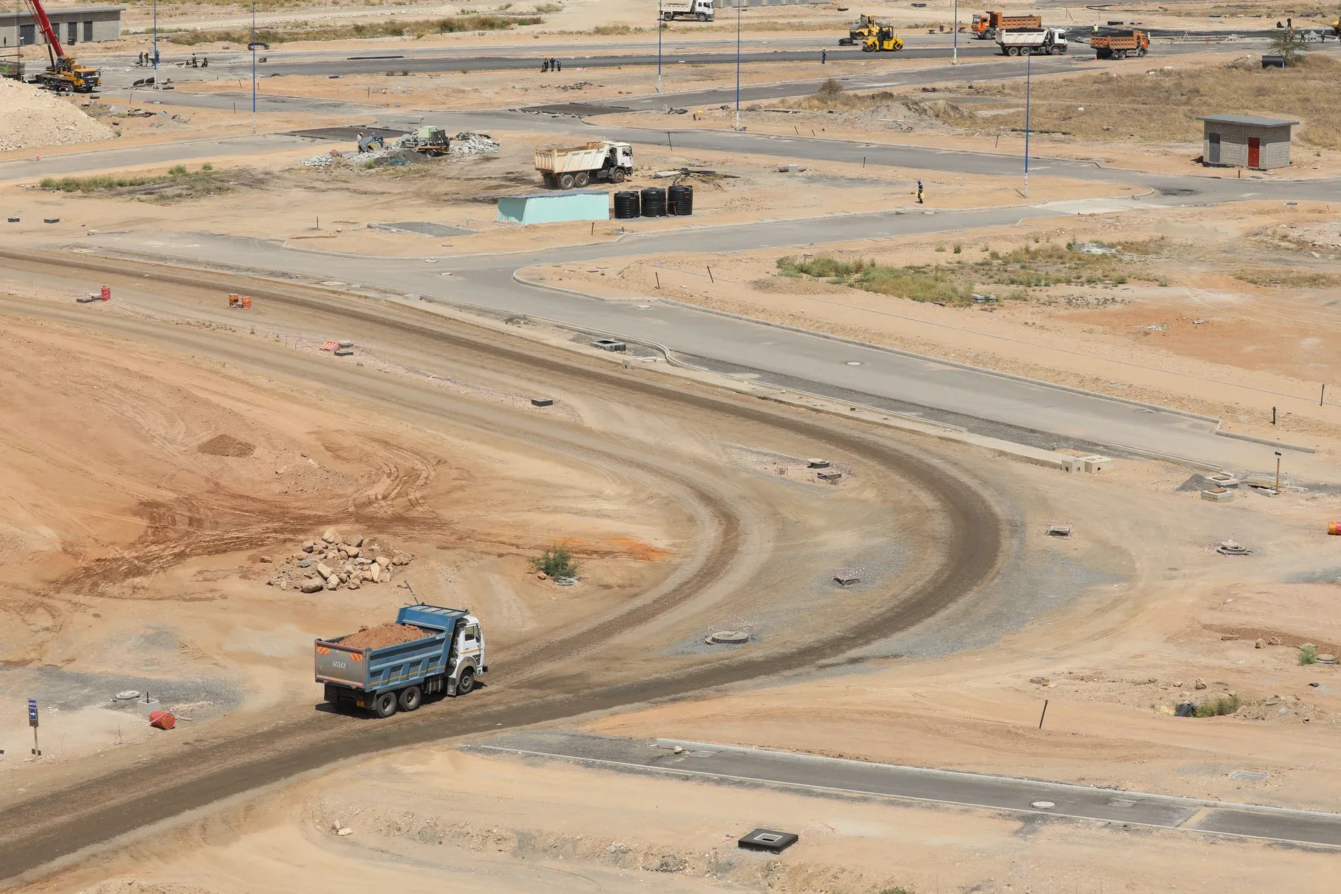 A newly surfaced multi-lane highway curving past a city interchange