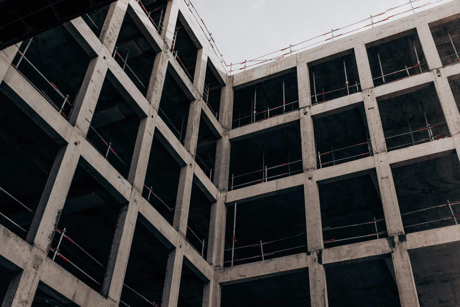 A reinforced concrete building frame rising beside a tower crane
